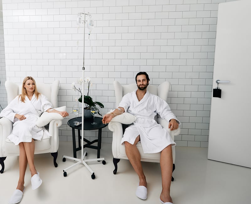 A professional nurse administering IV therapy drip to a client in a modern clinic