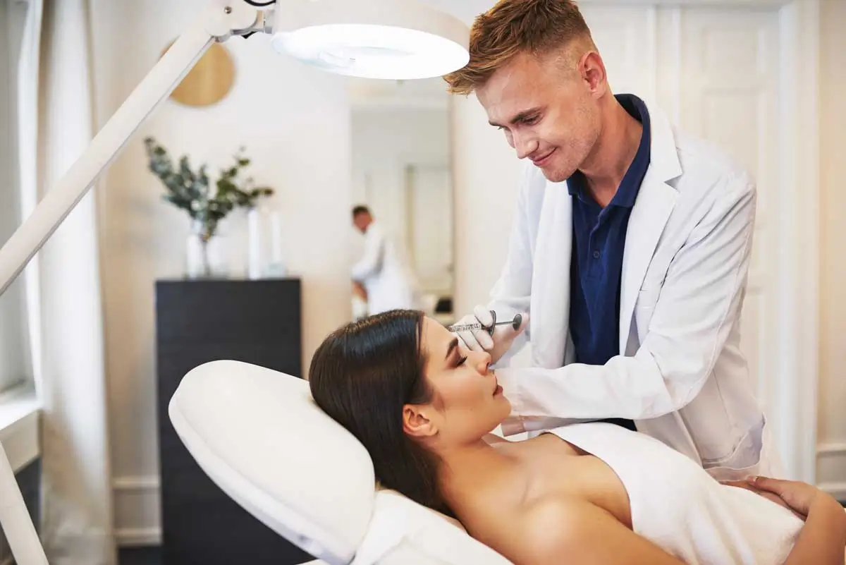 A cosmetic doctor administers an injection in a modern clinic. Clinics offering botox and fillers can scale with a cosmetic clinic marketing agency