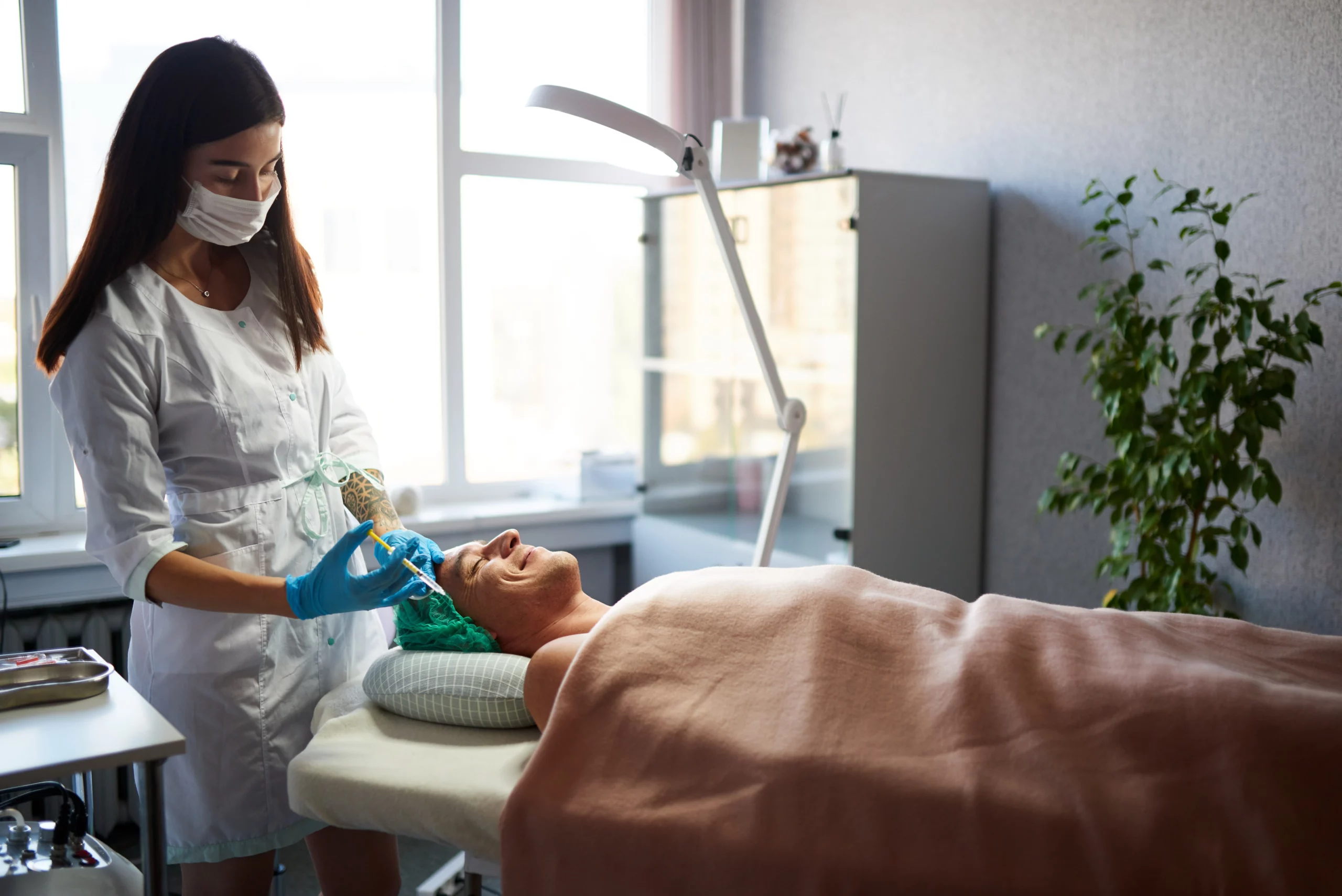 Aesthetic practitioner in a white coat and mask performing a cosmetic injection on a male client in a med spa setting, with natural lighting, modern equipment, and a calming interior. An ideal visual for content focused on how to attract new clients as a med spa by showcasing professionalism, client care, and trust-building experiences.